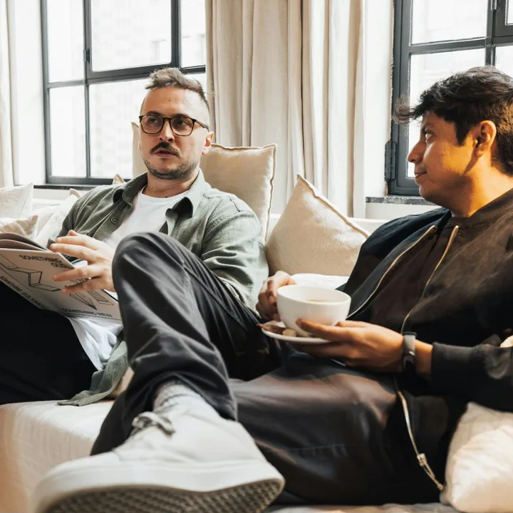 Two men talking openly on a couch